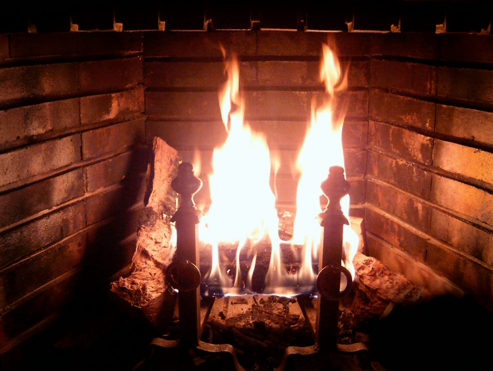 Real glowing fireplace fire in brick hearth